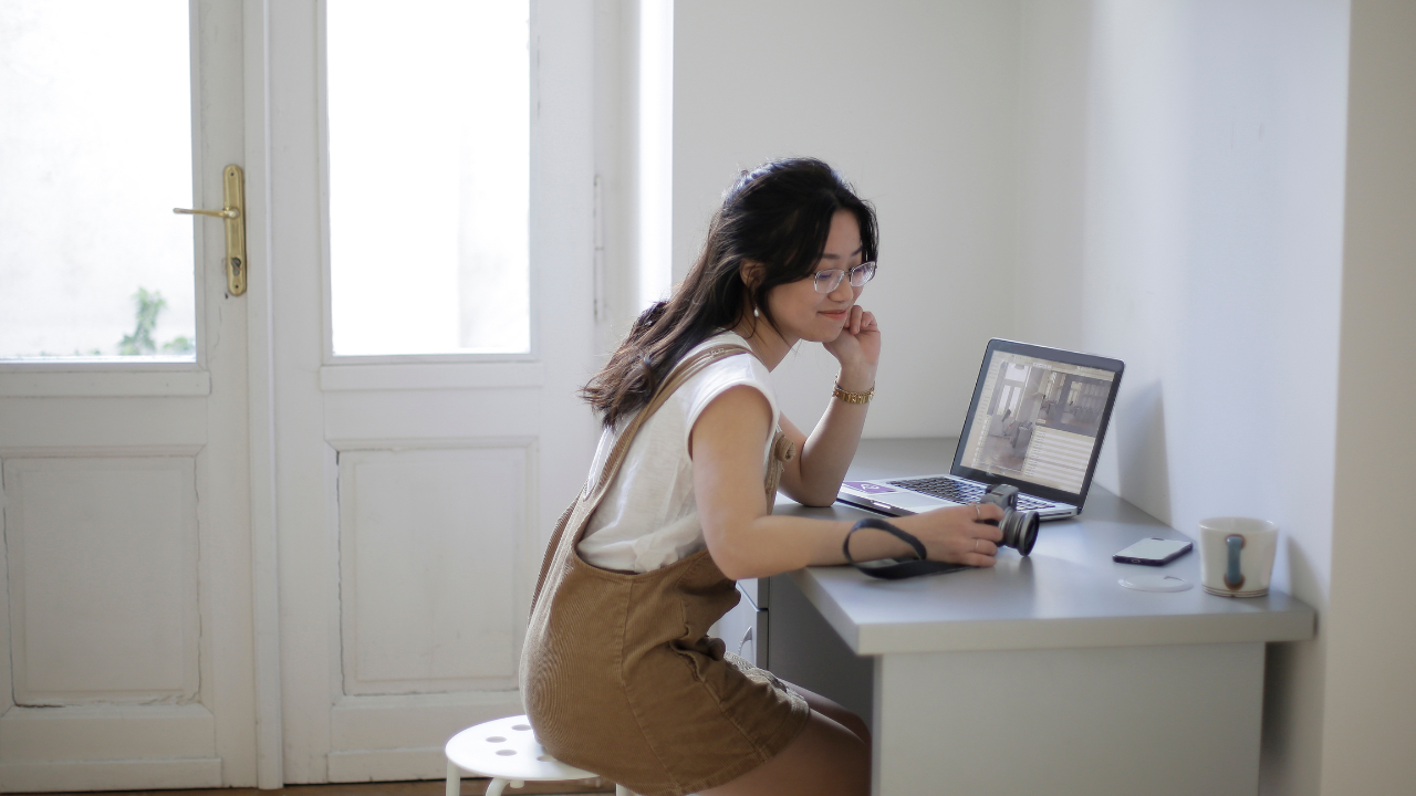 pcの前でカメラをみてる女性